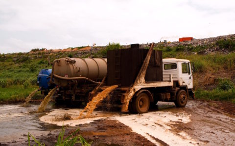 Truck loost inhoud latrines in een stabilisatievijver in Ghana